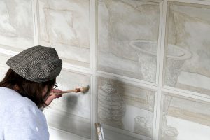 Frank Follaco peint un trompe l'oeil de fenêtre, avec ornements, dorure et intérieur